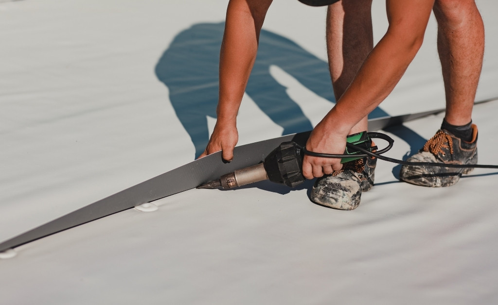 Image of commercial roofer welding roof membrane