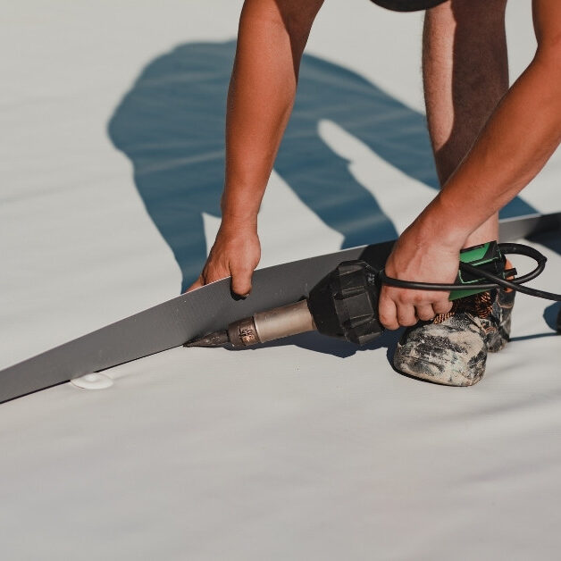 Image of commercial roofer welding roof membrane